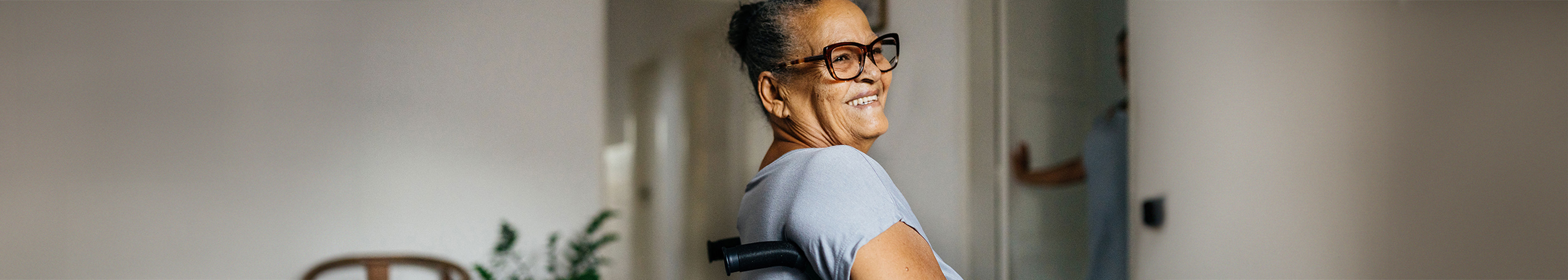 A woman sitting in a wheelchair smiling