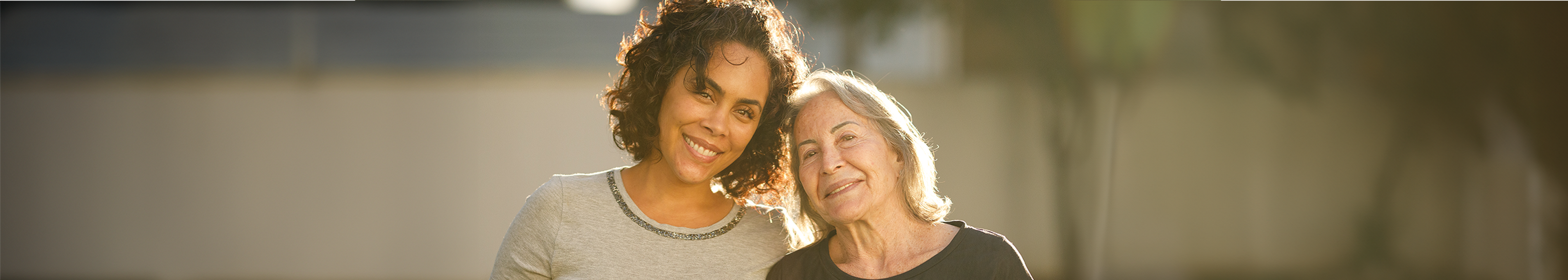 An Aboriginal woman in her 40s and a wise older woman in her 60s, smiling together, empowered to have a free breast screen.