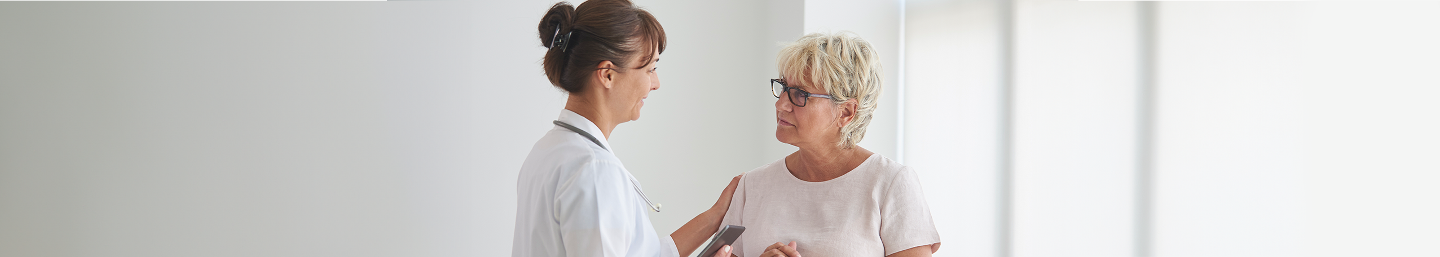 Female doctor talking to a female patient in her 50s about her mammogram 